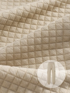 Gros plan sur un pantalon cargo en maille beige avec motif matelassé et tissu texturé