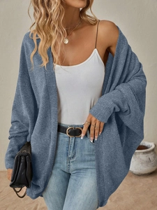 Dettaglio della trama a maglia e maniche a pipistrello di un cardigan lungo blu