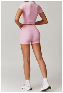 Rear view of pink short-sleeve crop top and high-waist biker shorts yoga set for women