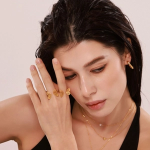 Gold plated butterfly open ring with layered star and pearl necklaces on model