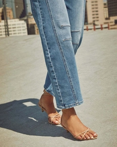 Dettaglio dei jeans dritti azzurri abbinati a sandali con cinturini beige