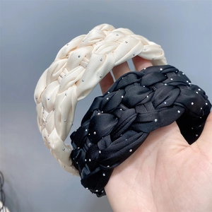 Detailed view of woven satin headbands in beige and black with sparkling rhinestones