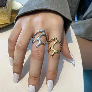 Close-up of golden and silver abstract liquid metal rings worn on fingers