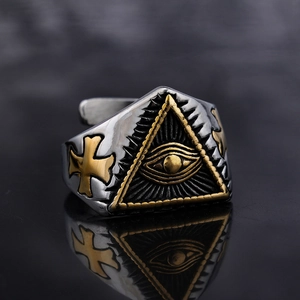 Macro shot of gothic stainless steel ring with golden All-Seeing Eye and cross symbols