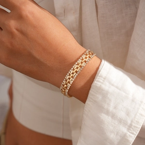 Detailed macro of gold-plated bracelet featuring triple rows of sparkling cubic zirconia
