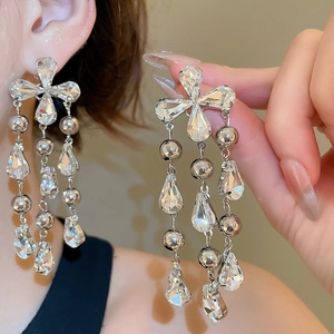 Macro detail of long tassel earrings with sparkling rhinestones and water drop pendants