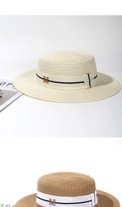 Détail d'un chapeau de paille canotier avec logo M en métal et ruban rayé élégant
