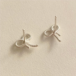 Detail of 925 sterling silver bow earrings with elegant twisted rope texture and silver finish