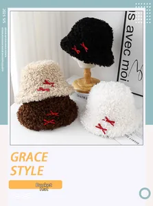 Détail de quatre bobs en peluche avec des nœuds rouges à pois sur supports en bois