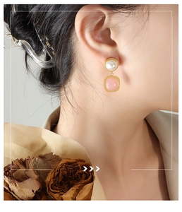 Elegant pearl and pink gemstone drop earrings shown on model with gold finish