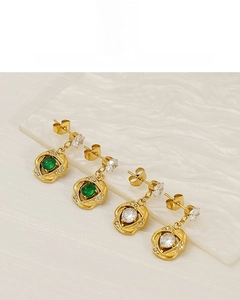 Detail of 18K vacuum plated rose-shaped earrings featuring emerald and white zircon