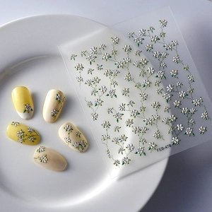 Detail of 3D embossed floral nail art stickers with white flowers and green leaves