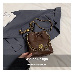 Details der dunkelbraunen Leder-Eimertasche mit Goldkette und verstellbarer Metallkugel