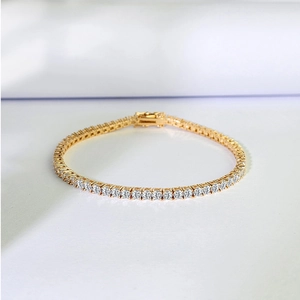 Close-up of golden tennis bracelet with single row of sparkling round zircons