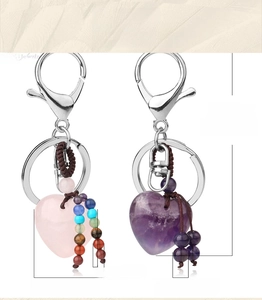 Detail of heart-shaped natural stone keychains with pink and purple crystals and beads