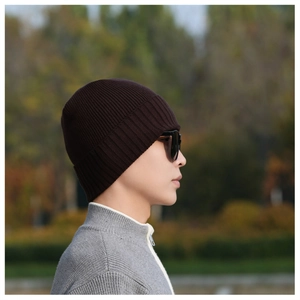 Outdoor shot of a thick dark brown ribbed knit beanie with a cozy textured finish