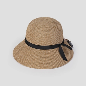 Detail view of khaki woven straw sun hat with black ribbon bow and elegant dome design
