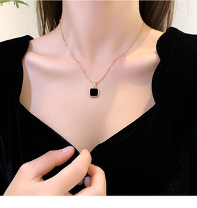Close-up of minimalist black square pendant on 18k gold plated stainless steel necklace