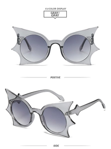 Front and side views of grey bat-shaped sunglasses with pointed frame and round lenses