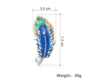 Detailed view of peacock feather brooch with blue enamel, crystals, and size dimensions