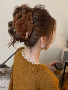 Detailansicht der braunen Plüsch-Haarklammer aus Webpelz mit Sweet-Label am Haar