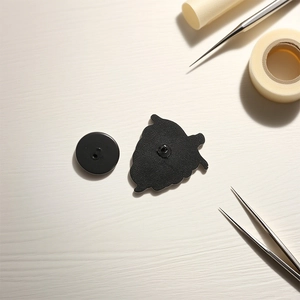 Creative skull alloy brooch badge with black rubber pin back on a textured wooden desk