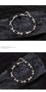 Macro view of silver bracelet featuring black rectangular stones and sparkling zircons