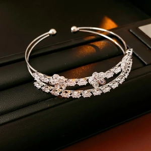 Détail macro du bracelet ouvert double couche argenté avec sertissage de fleurs en zircon