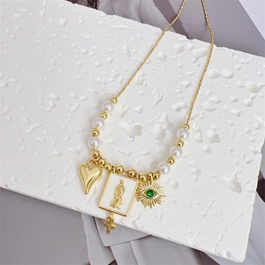 Détail du collier plaqué or 18 carats avec Saint-Benoît, perles et pendentif soleil
