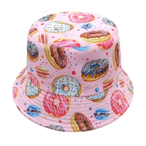 Detailed close-up of pink bucket hat with colorful donut and macaron pattern prints