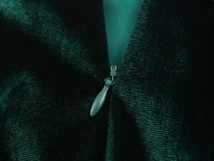 Macro view of a high-quality invisible zipper on dark green velvet dress fabric