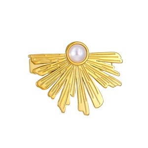 Detailed view of a golden vintage fishtail fan hair clip with a centered white pearl