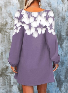 Detail of floral tulip print on purple V-neck dress with balloon sleeves and open back