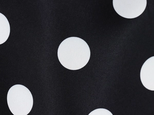 Detailed close-up showing white polka dot pattern on black fabric with fine textile texture