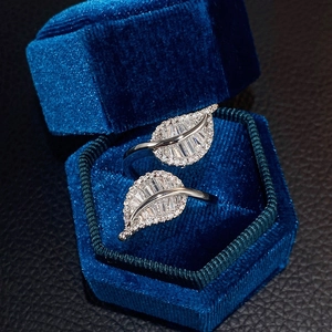 Close-up of leaf-shaped silver ring with zircon inlay in a blue hexagonal velvet box