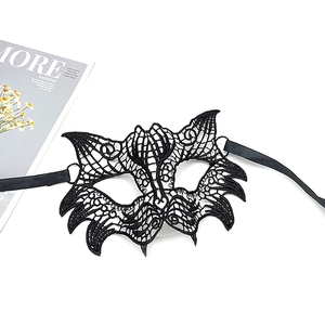 Detail view of a black lace cat-shaped masquerade mask with silk ribbon ties on white background