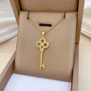 Close-up of gold-plated key pendant necklace with zircon-encrusted star and clover detail