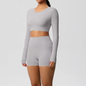 Detail van de yoga shorts met hoge taille en zijzak en crop top met lange mouwen grijs