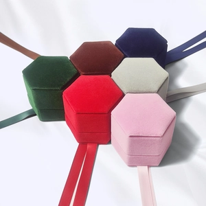 Hexagonal velvet jewelry boxes with silk ribbons in multiple colors on silk background