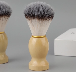 Detail of wooden handle shaving brush with soft synthetic bristles and gold metal ring