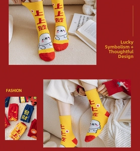 Détail de chaussettes en velours corail jaune et rouge avec caractères porte-bonheur