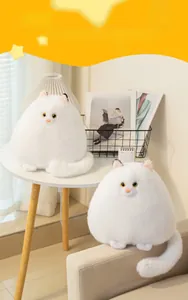 Close-up of soft white plush Persian cat toy with fluffy fur and yellow eyes in home setting