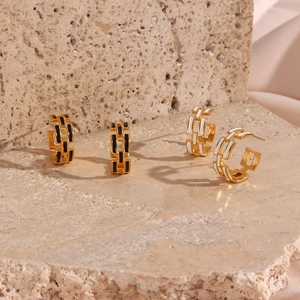 Detail of C-shaped chain earrings in gold with black and white enamel on stone