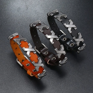 Close-up of three woven leather blessing bracelets in orange, dark brown, and black colors