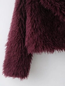 Macro shot of fluffy burgundy faux fur fabric showing soft plush texture and long fibers