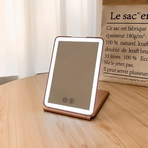 Macro detail of rose gold LED folding makeup mirror with touch control and dimmable light
