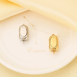 Makroaufnahme von goldenen und silbernen Oval-Verschlüssen für DIY-Schmuck auf Keramikteller
