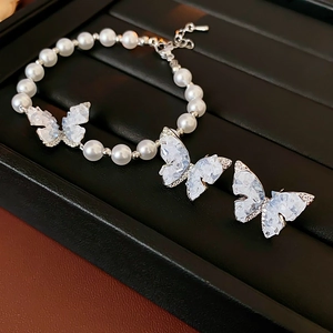 Gros plan détaillé d'un ensemble de bracelet en perles et boucles d'oreilles papillon