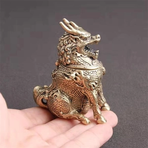 Macro detail of antique bronze miniature kylin censer held by hand showing small scale