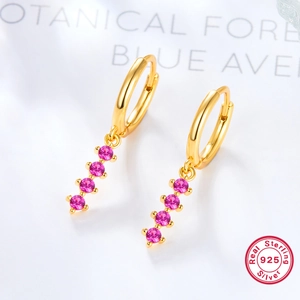 Macro shot of 925 silver earrings with pink zircon stones and gold plating finish